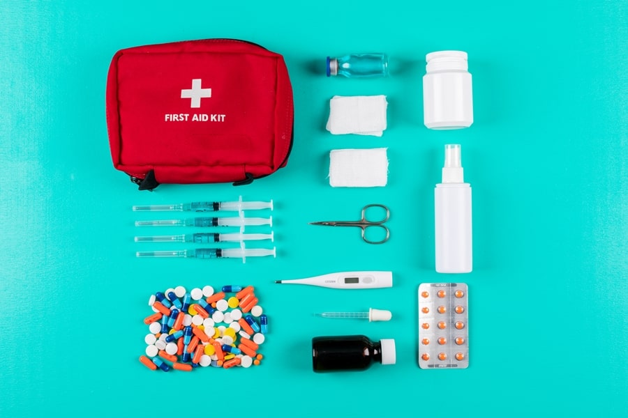 flat-lay-first-aid-kit-with-pills-thermometer-spray-pills-bandage-cyan-blue-background-horizontal-900-min